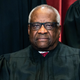 Supreme Court Justice Clarence Thomas sits during a group photo at the Supreme Court in Washington, April 23, 2021.